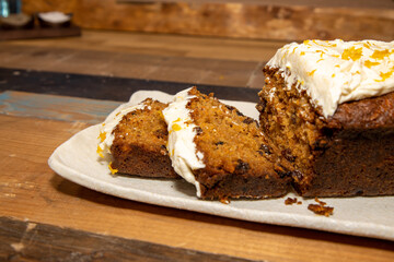 A delicious carrot cake on a wooden kitchen work top