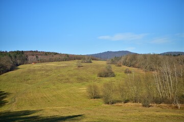 Panorama of white blue sky over forest greenery in sunny autumn