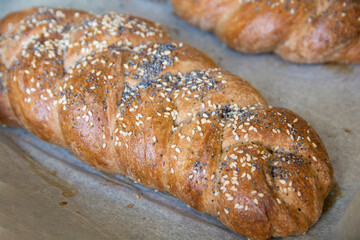 Traditional baked Challah bread, made of spelt flour, with topping of sesame and poppy seeds