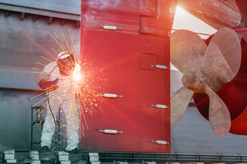Industrial business concept with technician focus on welding process for ship repair at rudder and...