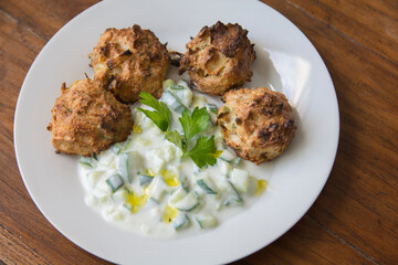 Traditional Greek patties, made of leek and cheese, served with Tzatziki sauce in a plate
