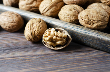 Walnuts on a dark brown wooden background. Close up. Selective focus, side view. Copy space.