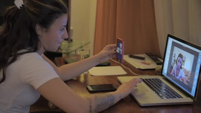 woman have online video chat using digital computer and smartphone, sitting in the living room