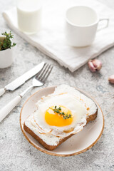Breakfast of toast with fried egg on a plate, selective