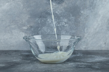 Splashing organic milk into glass bowl