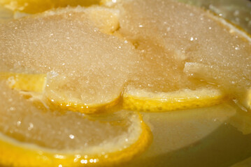 Fototapeta na wymiar Sliced lemon sprinkled with sugar closeup. Shallow depth of field