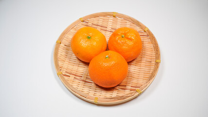 ザルに乗った新鮮な温州ミカンのイメージ
