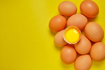 Chicken eggs on a yellow background with yolk.