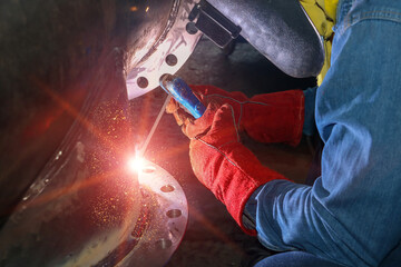 Welder is Welding close up with Metal Steel pipe in factory with spark light on Monochrome tone