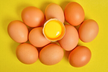 Chicken eggs on a yellow background with yolk.