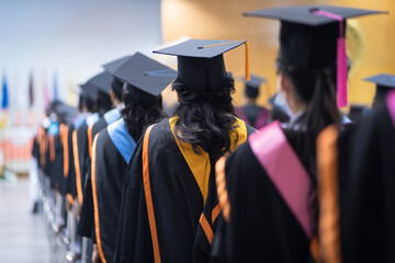 Rearview of the university graduates line up for degree award in university graduation ceremony....