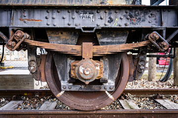 Fototapeta na wymiar Close up of a side view of a rusty old railway carriage wheel