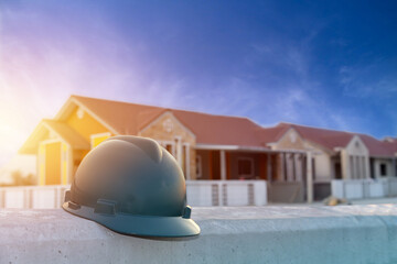 Green helmet safety on concrete in vinllege construction project site on blue sky