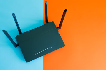 two-channel black router with four antennas on a two-color background