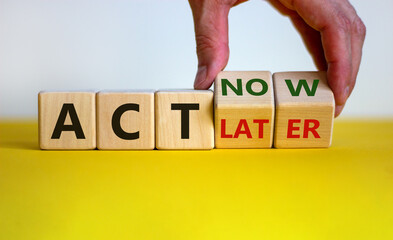 Act now, not later symbol. Male hand turns wooden cubes and changes words 'act later' to 'act now'....