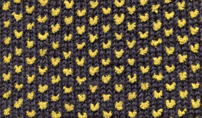 texture of crocheted dark fabric with simple yellow polka dot pattern