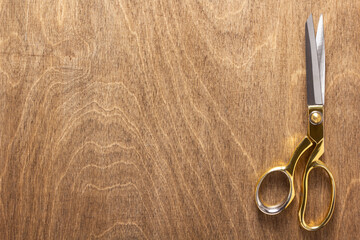 tailor or sewing scissors on wooden table background