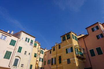 Fototapeta na wymiar The colourful ancient facades of houses in Imperia old town, Liguria region, Italy