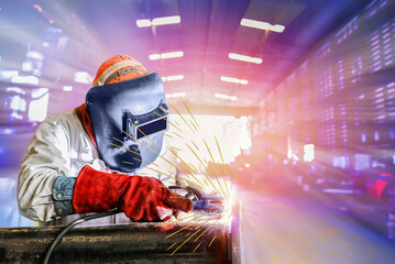 Fototapeta na wymiar Industrial worker at the factory welding close up with spark light wear equipment protective PPE and Mask weld