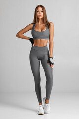 Beautiful fitness woman. Athletic girl on the gray background