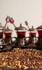 Dry ground rosehip tea and Turkish teacups with spoons.