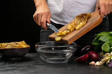 Cooking process, woman cut baked eggplant