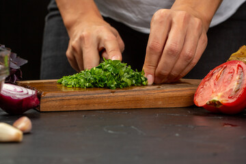 Cooking process, woman cut greens for aubergine paste
