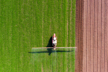 Pesticide Sprayer Tractor working on a large field, Aerial view. © STOCKSTUDIO