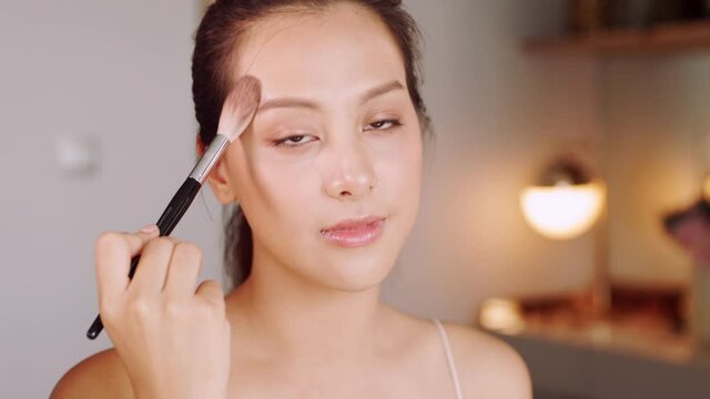Happy attractive asian woman apply skincare cream on face and body.Female  hand touch face  and smooth applying cream and lotion for rejuvenation, beauty perfect with wellness, skin care .