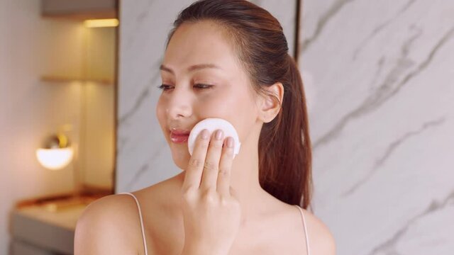 Happy attractive asian woman apply skincare cream on face and body.Female  hand touch face  and smooth applying cream and lotion for rejuvenation, beauty perfect with wellness, skin care .