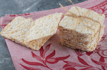 Stack of tasty crispbread on red cloth