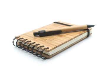 Closeup of wooden bamboo notebook and pen on white background