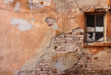 An old, peeled brick wall and a window