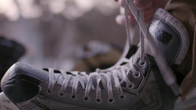 Lacking up ice skates. Winter sports and hockey skates. Getting ready to get on the ice. Snow and winter wonderland
