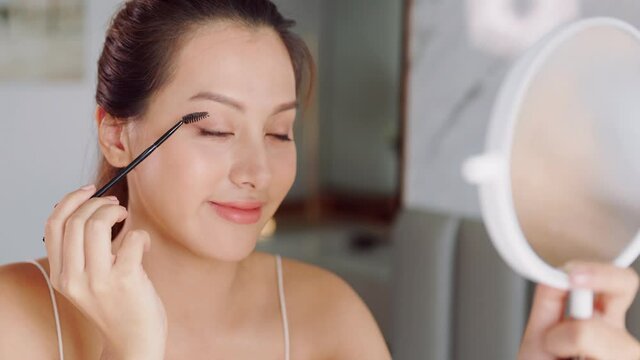 Happy attractive asian woman apply skincare cream on face and body.Female  hand touch face  and smooth applying cream and lotion for rejuvenation, beauty perfect with wellness, skin care .