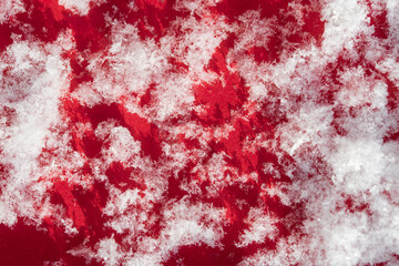 Abstract red and white natural background. Snow flakes on a red background close-up.