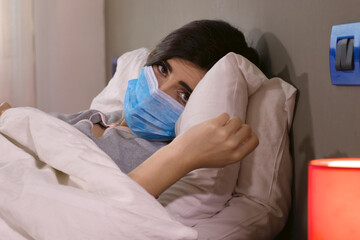 Woman sick in hospital bed with coronavirus sad looking camera