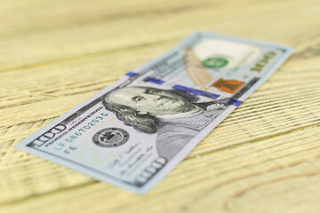 Hundred dollar bills on a wooden background.