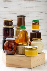 Various canned foods in jars on a light wooden background. Organic food.