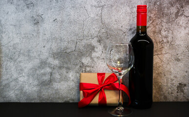 St. Valentines Day concept. Composition of wine, glasses and gift box on cement background.Romantic concept. Love