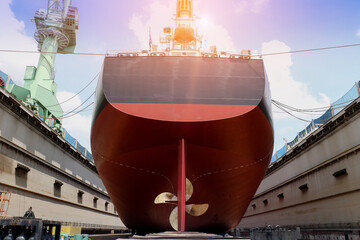 Propeller center of Stern of Big Cargo ship Moored on sleeper wood ship at floating dry dock in...