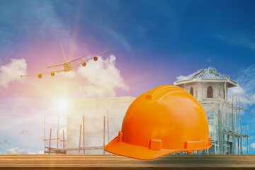 Safety first project of worker as engineer or worker or crew and insurance, business concept, construction safety, Yellow hard safety helmet on wooden floor and building construction background.
