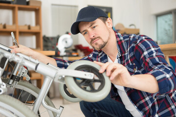 man repairing a wheelchair in workshop