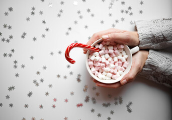 cup with marshmallows on a white background with silver snowflakes