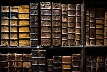 Heavy Leather-Bound Books On Bookshelves In A Cathedral Library