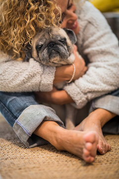 Pet therapy and love animal dog concept with lonely woman at home hugging her own pug on the floor - brown tones image of people hone lifestyle