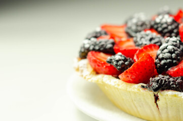 Butter enriched shortcrust pastry topped strawberries and blackberries, seasonal cake with colorful decoration