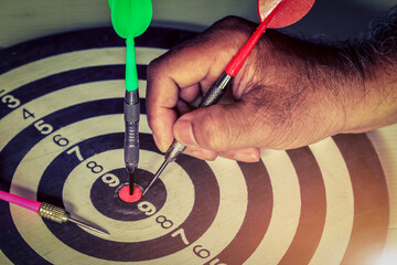 Hand trowing dart to dartboard for Targeting,and green hitting on dartboard,Target business,...