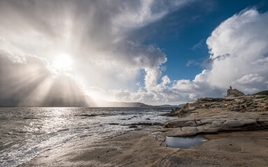 Sun rays burst through cloud onto Mediterranean in Corsica