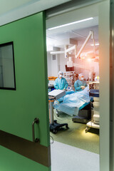 Group of surgeons in operating room with surgery equipment. Modern medical background. Selective focus.
